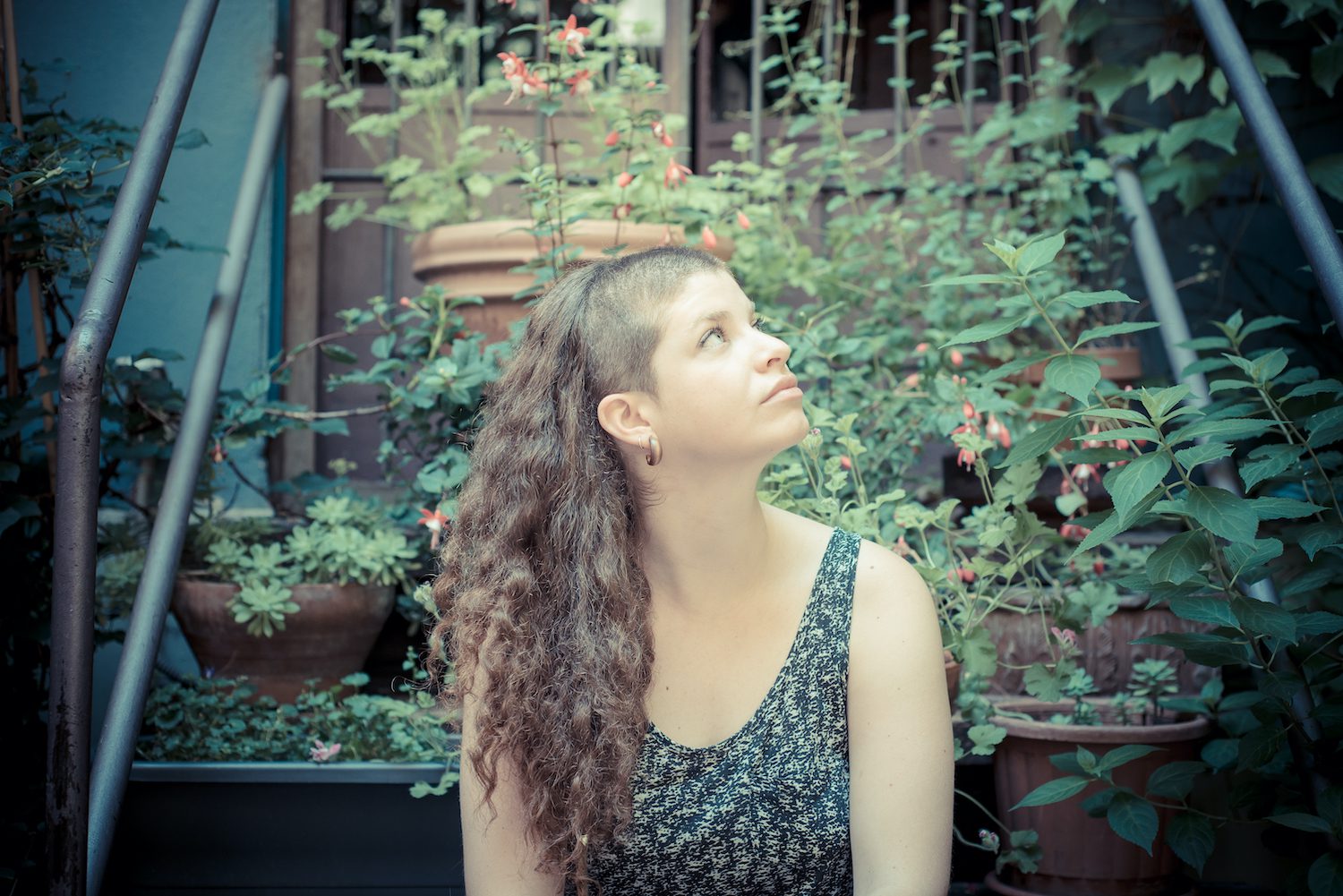 Young woman in the city looking up.