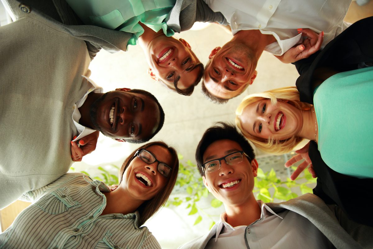 Happy people with their heads together representing a concept of friendship and support.