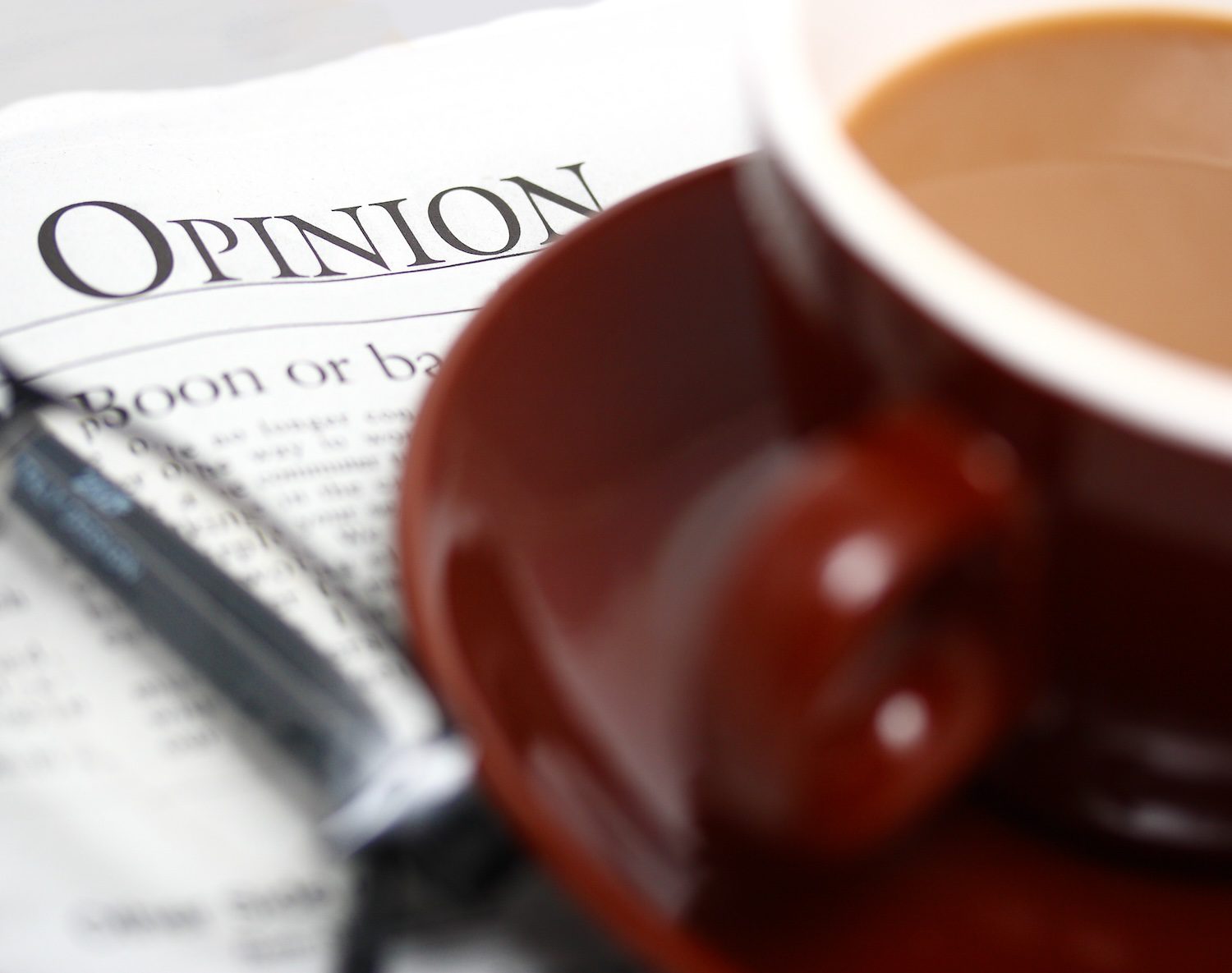 Having A Cup Of Coffee And Looking At The Opinion Section Of The Newspaper.