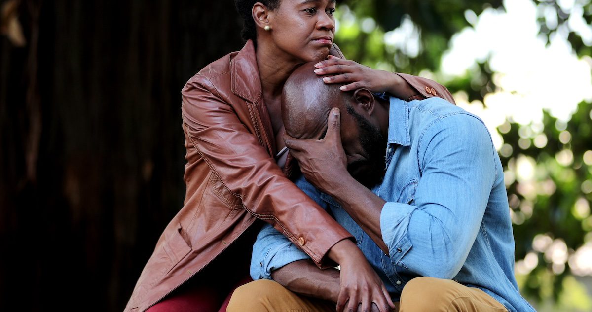 African American woman sitting consoling her partner.