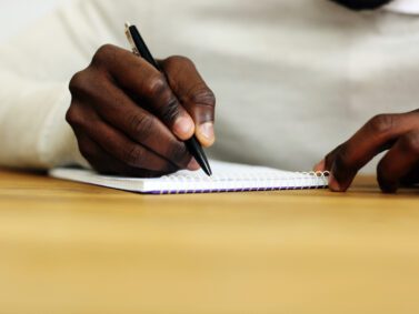 Closeup portrait of a male hand writing on a paper.