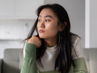 Sad Asian woman thinking about her risk for addiction